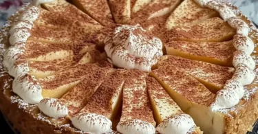 Apfelkuchen mit Sahne-Zimt-Haube auf einem Teller serviert