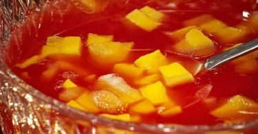 Erfrischender alkoholfreier Pfirsich Mandarinenpunsch in einem dekorativen Glas