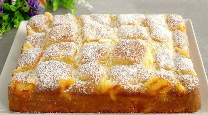 Ein saftiger Apfelkuchen mit Vanillepudding auf einem Teller