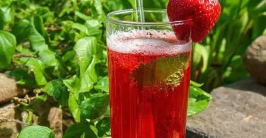 Erfrischender Erdbeer-Punsch in einem Glas mit Erdbeeren und Minze.