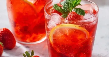 Erfrischende Erdbeerlimo in einem Glas mit frischen Erdbeeren