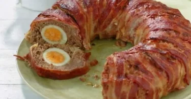 Hackbraten mit Überraschung serviert auf einem rustikalen Holzbrett.