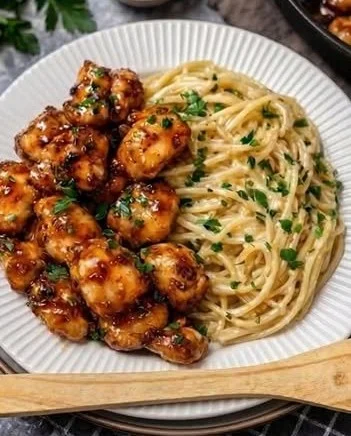 Honig-Knoblauch-Hähnchen serviert mit cremigen Spaghetti auf einem Teller