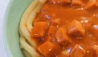 Makkaroni mit Tomatensoße und Jagdwurst auf einem Teller serviert