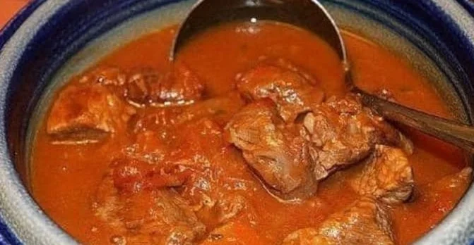 Omas uraltes Gulasch mit frischen Zutaten und Gewürzen auf einem Teller serviert.