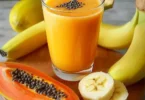Köstlicher Papaya-Bananen-Smoothie in einem Glas mit frischen Früchten