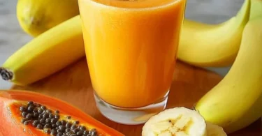 Köstlicher Papaya-Bananen-Smoothie in einem Glas mit frischen Früchten