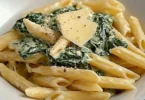 Penne mit Spinach-Gorgonzola-Sauce auf einem Teller serviert