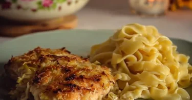 Pollockfilet mit knuspriger Lauch-Zwiebel-Kruste auf einem Teller serviert