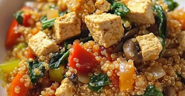 Leckeres Quinoa-Jambalaya mit Gemüse und Gewürzen auf einem Teller serviert.