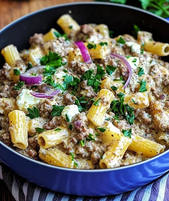 Rigatoni in einer cremigen Hack-Feta-Sauce serviert auf einem Teller.