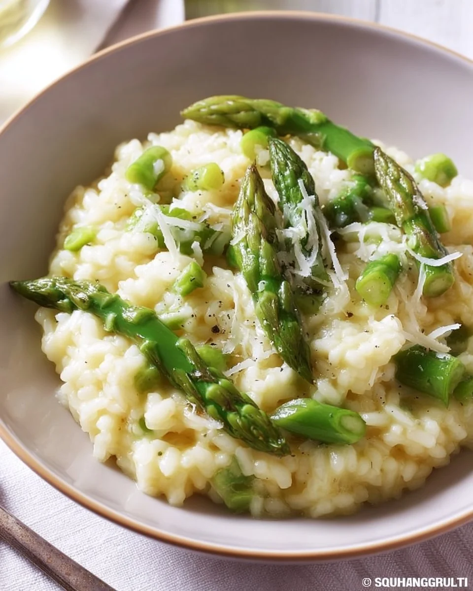 Leckeres Risotto mit grünem Spargel auf einem Teller serviert.