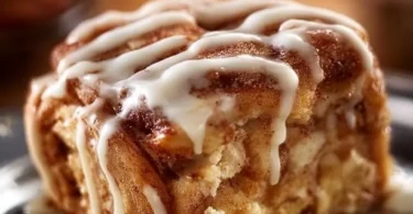 Saftiger Zimtschnecken Apfelkuchen auf einem Teller mit Zimt bestreut