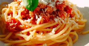 Schüssel mit Spaghetti Thunfisch, garniert mit frischen Kräutern.