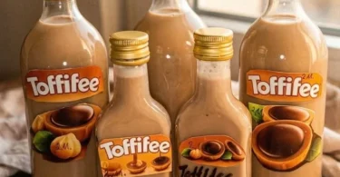 Glas mit Toffifee Likör, umgeben von Toffifee Süßigkeiten