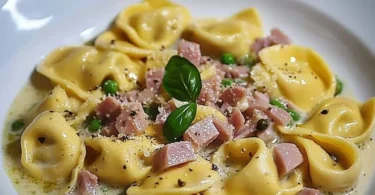 Tortellini in Schinken-Sahne-Sauce auf einem Teller serviert