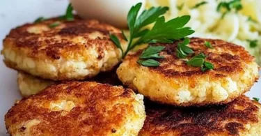 Vegetarische Blumenkohl-Patties auf einem Teller serviert mit frischen Beilagen.