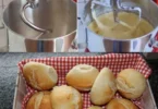 Frisch gebackene Brötchen auf einem rustikalen Holzbrett.