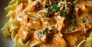 Cremiges Hähnchenragout mit Bandnudeln auf einem Teller angerichtet