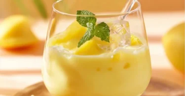 Eierlikörbowle mit Ananas und Sekt in einem Glas, dekoriert mit Früchten