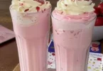 Erdbeermilch in einem Glas mit frischen Erdbeeren dekoriert