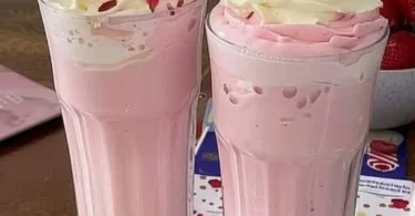 Erdbeermilch in einem Glas mit frischen Erdbeeren dekoriert
