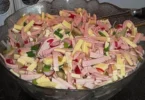 Bunte Schüssel mit Gouda Wurst Salat, frischen Zutaten und Dressing