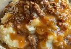 Hackfleisch und Soße serviert über Kartoffelpüree auf einem Teller