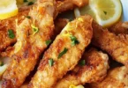 Hähnchenstreifen mit Zitrone und Knoblauch auf einem Teller serviert