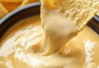 Nacho-Käse-Sauce in einer Schüssel mit Tortilla-Chips