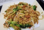 Schmackhafte chinesische gebratene Nudeln mit Hühnchen auf einem Teller