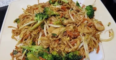 Schmackhafte chinesische gebratene Nudeln mit Hühnchen auf einem Teller