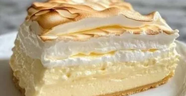 Ein frisch gebackener Tränchenkuchen auf einem Teller, dekoriert mit Sahne.