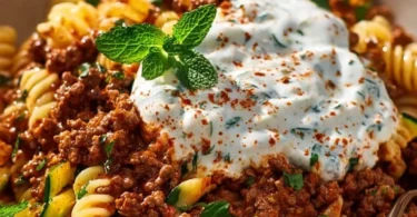 Türkische Pasta mit Hackfleisch und Joghurt-Sauce auf einem Teller angerichtet.
