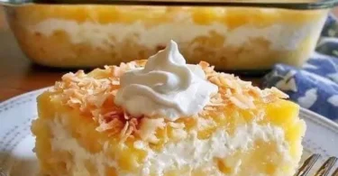 Ananas-Kokos-Traumkuchen auf einem Teller, dekoriert mit frischem Obst.
