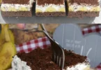 Leckerer Banana Schokoladenkuchen mit Sahne auf einem Teller serviert.