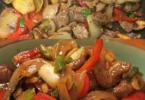 Chinesisches Rindfleisch mit Zwiebeln und Paprika auf einem Teller serviert