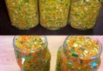 Schüssel mit frisch zubereiteter Gemüsebrühe und frischem Gemüse auf einem Holzuntergrund.