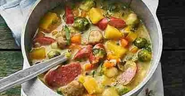 Eine Schüssel Gemüsesuppe mit Mettwurst garniert