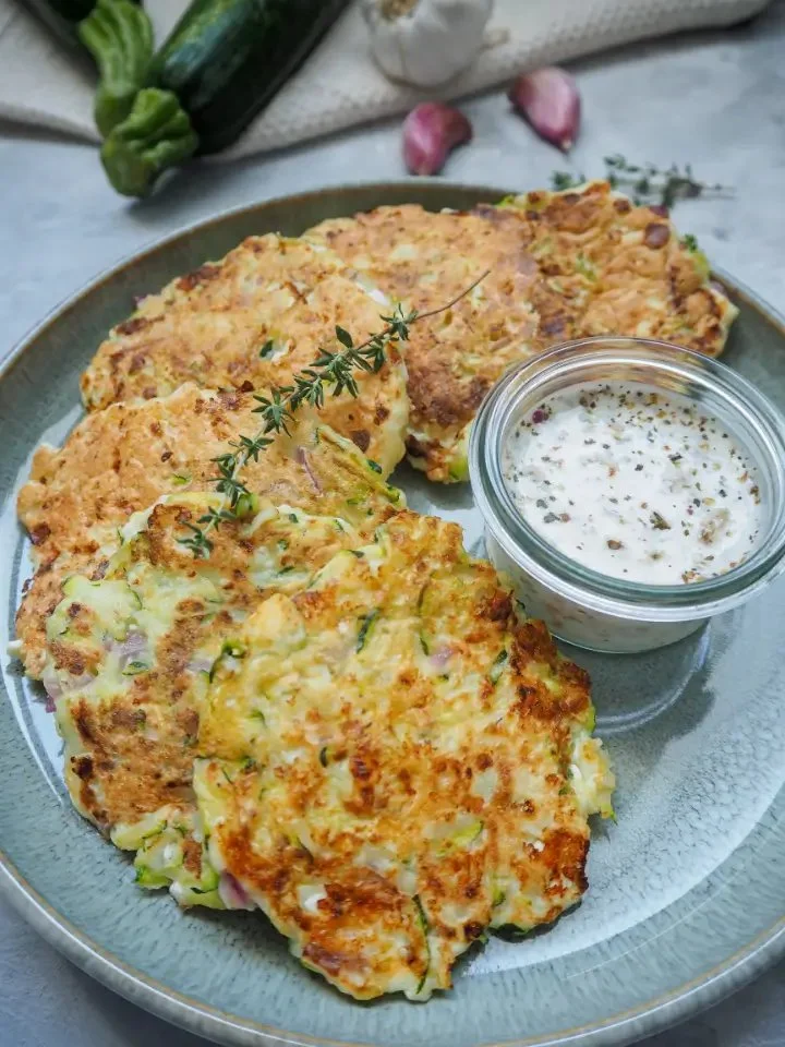 Gesunde Hüttenkäse-Puffer aus der Pfanne auf einem Teller serviert.