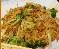 Gewürzte chinesische gebratene Nudeln mit Hühnchen auf einem Teller serviert.