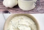 Knoblauch-Joghurt-Sauce in einer Schüssel, serviert mit frischem Gemüse.