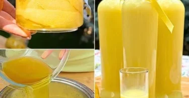 Flasche Limoncello Likor mit frischen Zitronen auf einem Tisch