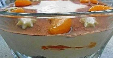 Schichtdessert mit Schokoladenkeksen und Mandarinen in einer dekorativen Glasschale