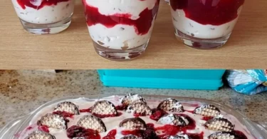 Schichtdessert mit Schokoladenküssen und rotem Fruchtkompott auf einem Teller