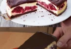 Schwarzwälder Käsekuchen mit Kirschen und Schlagsahne auf einem Teller