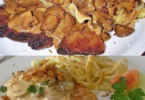 Schweineschnitzel mit Pilzrahmsauce und Spätzle serviert auf einem Teller