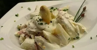 Spargel-Eiersalat mit Schinken auf einem Teller serviert