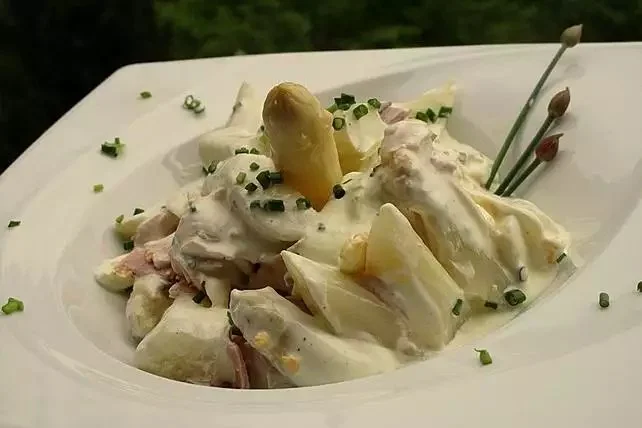 Spargel-Eiersalat mit Schinken auf einem Teller serviert