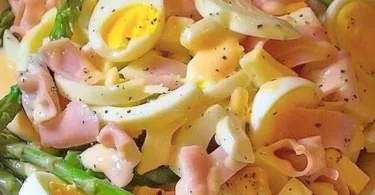 Spargelsalat mit Schinken und Eiern auf einem Teller angerichtet